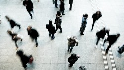 A busy train station with silhouettes of people walking.